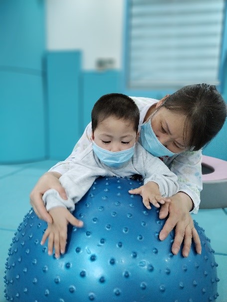 病患孤儿宝贝在妈妈的陪伴下进行康复训练.jpg